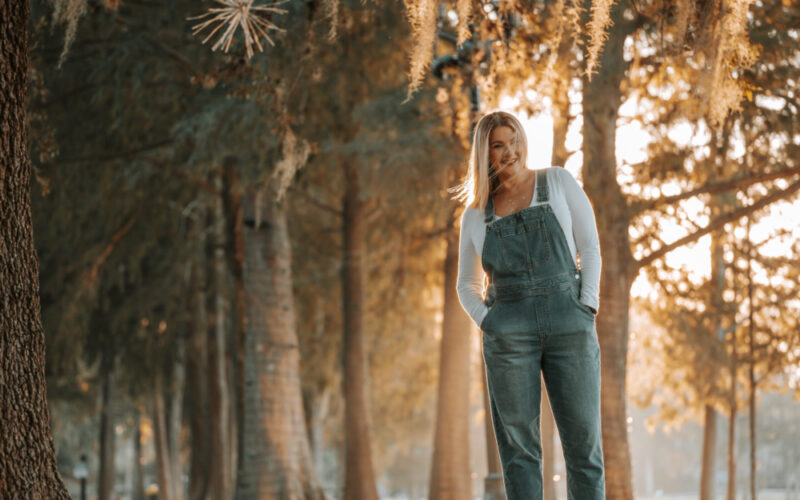 Picture of author Jill Carlyle standing in front of trees in an outdoor setting