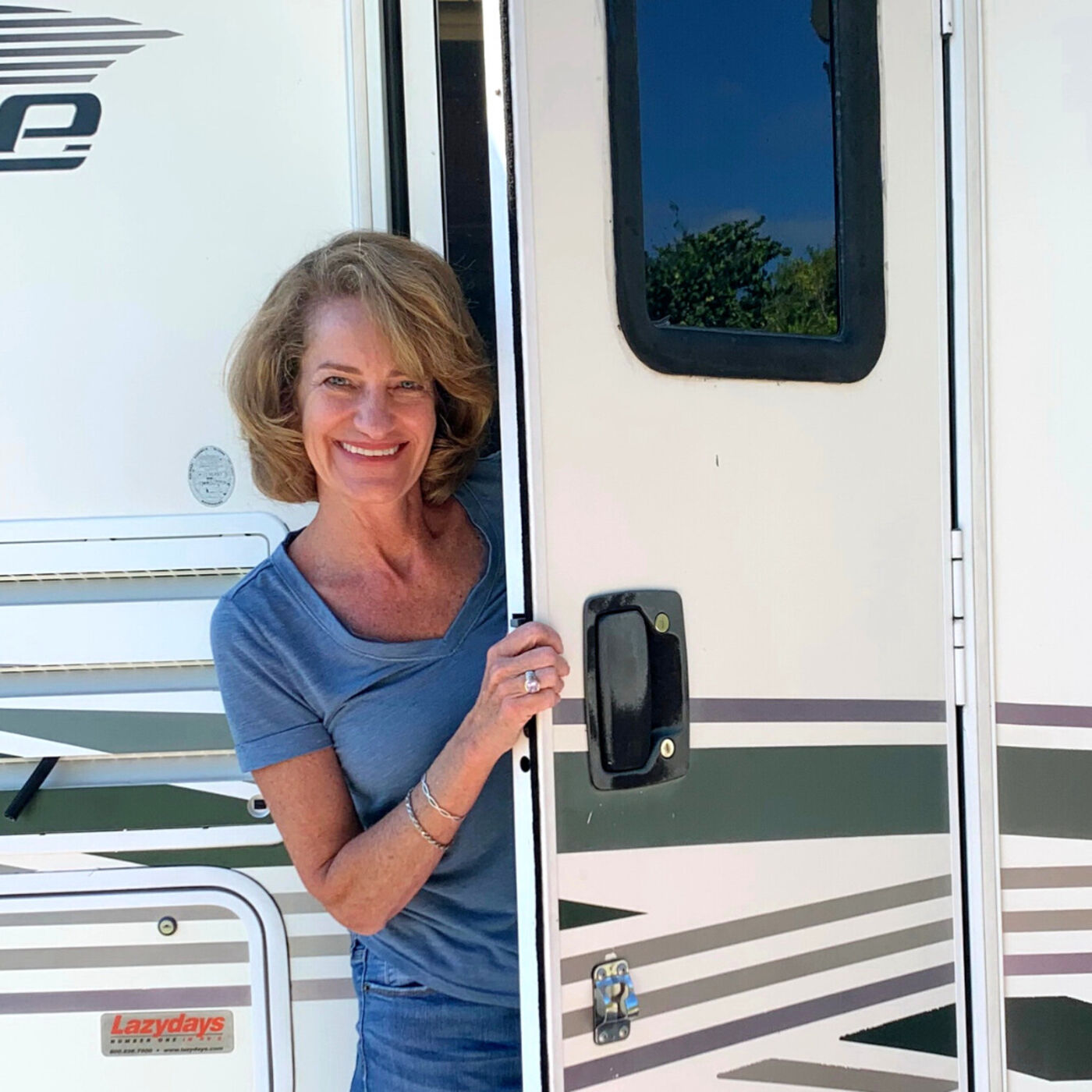 Reinvention after 50 - picture of Michelle Fisbhurne. She is standing with the door open of her RV