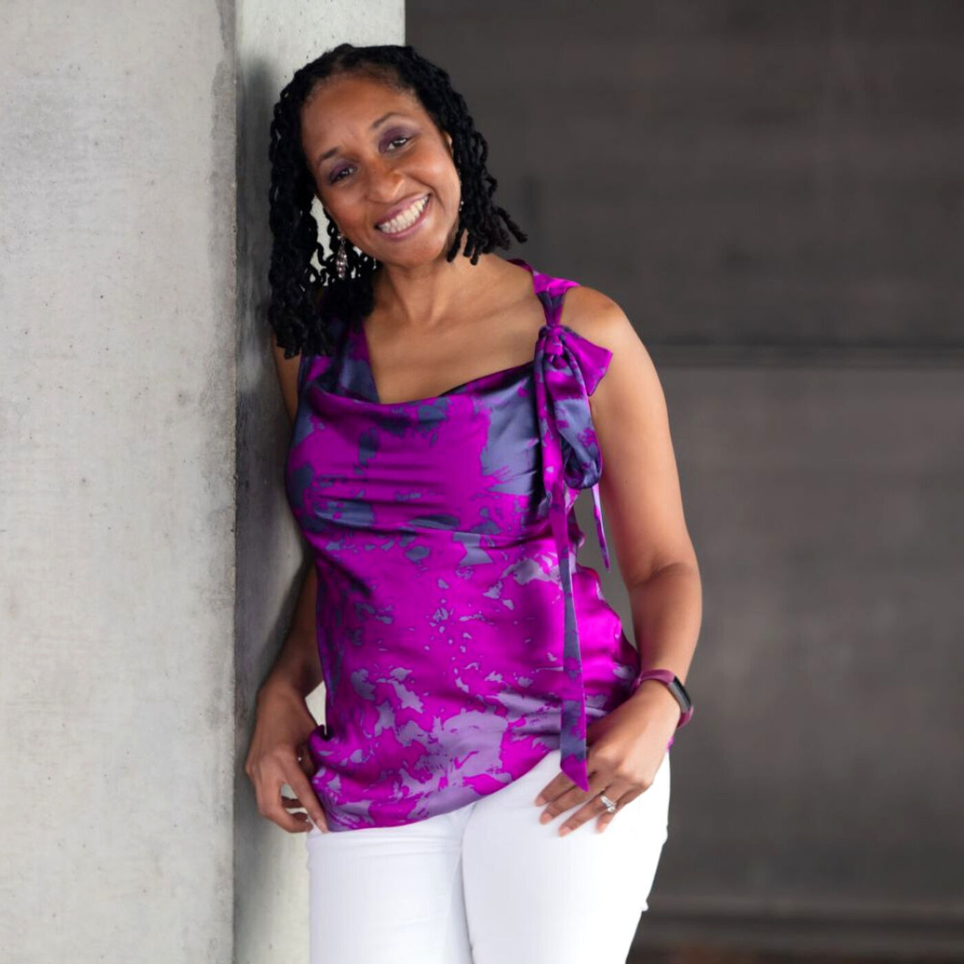 Reinvention After 50: Picture of Wendy in a purple top leaning against a cement pillar.