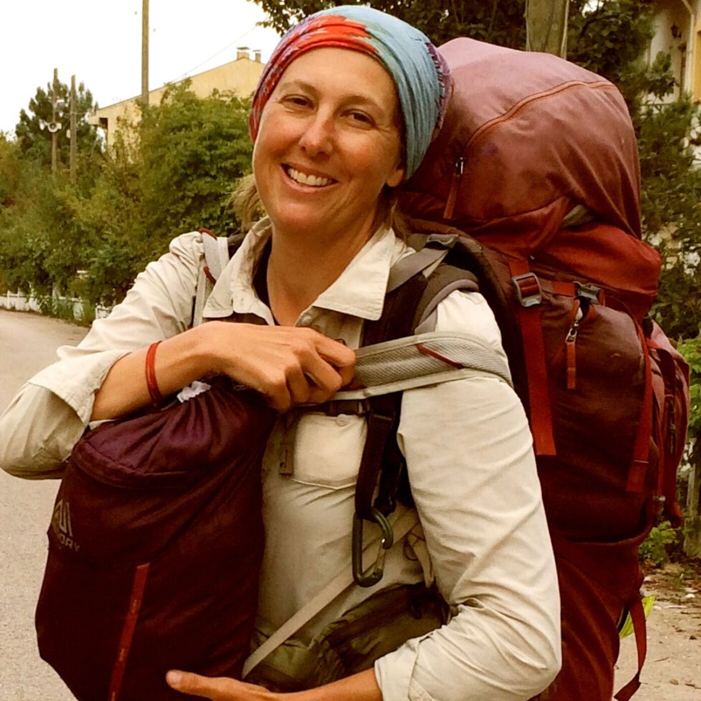 Midlife reinvention queen Jenn Baljko has reinvented herself many times from her 20s to her 50s. She's pictured with a large backpack on her back and a smaller backpack on her front as she treks from Bangkok to Barcleona