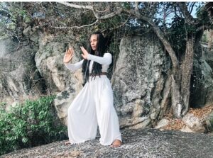 Menopause ushers in new possibilities. Just ask Dixie Lincoln-Nichols, she's reinvented. She is pictured outside in a park with her arms raised doing Qigong.