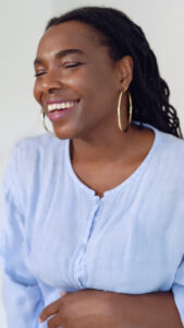 Midlife reinvention starts within in. We can transform our lives in menopause. Picture of Monique Cupid smiling in a blue shirt.