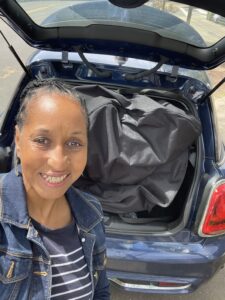 Midlife reinvention looks different for each of us. Picture of Wendy Btattles smiling and standing in from of the back of a car