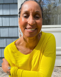 Reinventing starts within. Picture of Wendy in a yellow sweater, smiling into the camera and looking calm and relaxed.