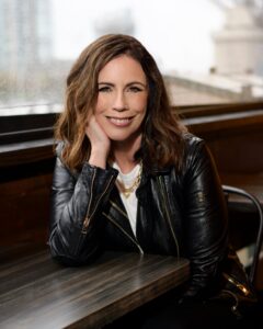 Selfish Year author Valerie Jones wearing a black leather jacket smiling into the camera